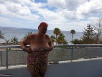 Obese nan with spiky red hair unveils her tits on balcony before posing naked - Photo #9